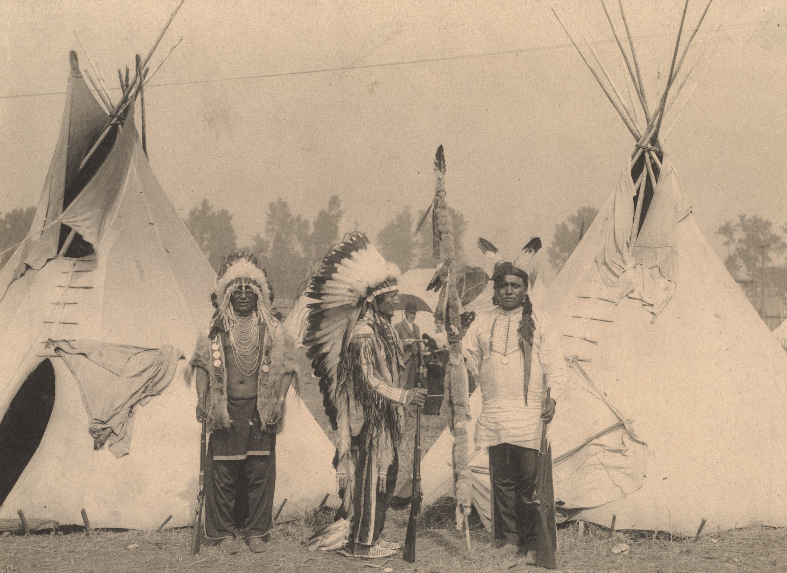 Black Foot, Standing Bear, Big Eagle, Sioux. Three members of the Sioux tribe pose in Indian Village, 1898