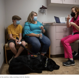 A mother and son speak with a Dr. at the clinic.