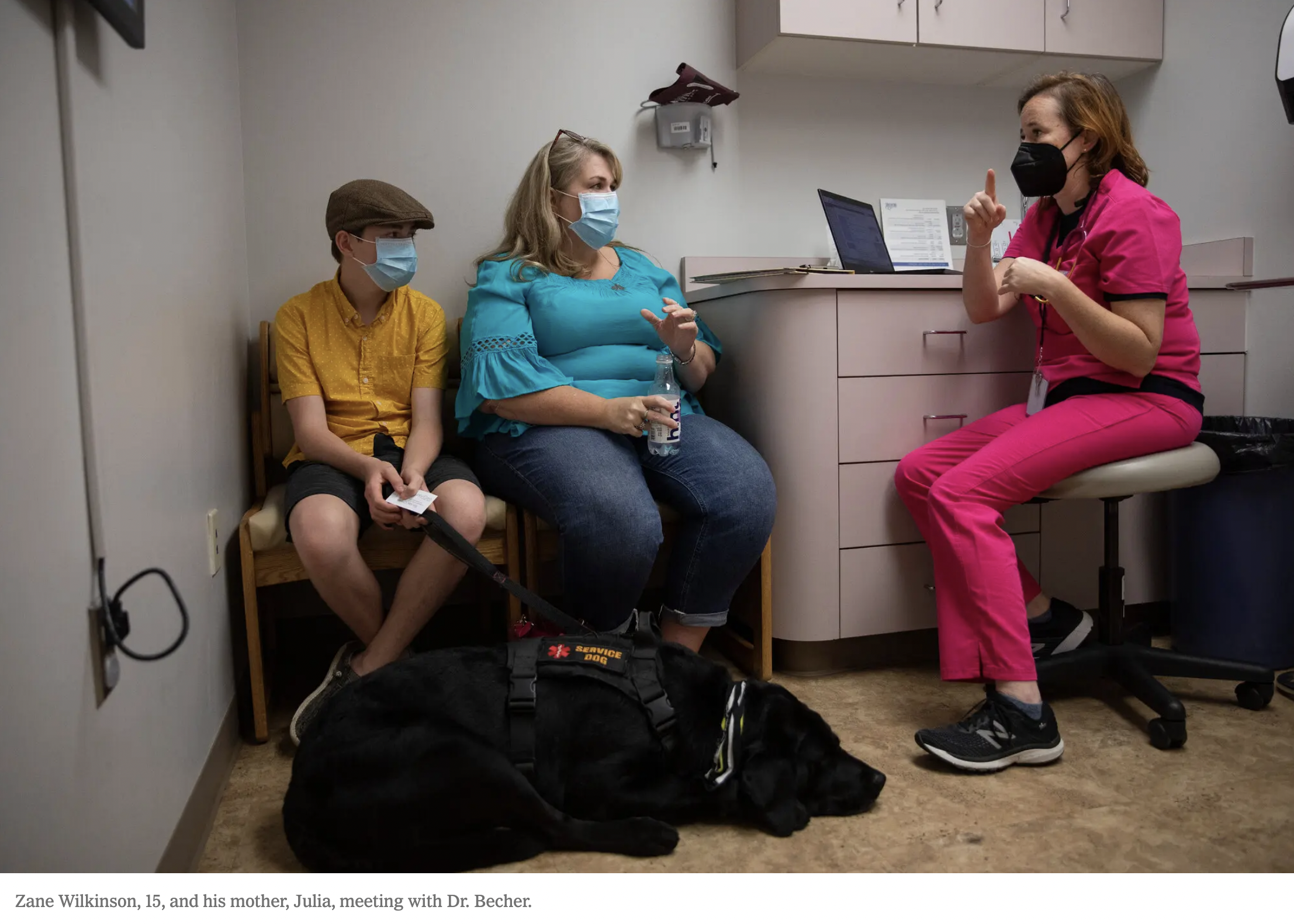 A mother and son speak with a Dr. at the clinic.