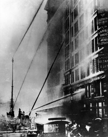 Firefighters from ladder company 20 spray water toward the building in an effort to cool workers who were forced to the window ledges by the extreme heat. Photographer: Brown Brothers, 25-Mar-11 (National Archives and Records Administration)